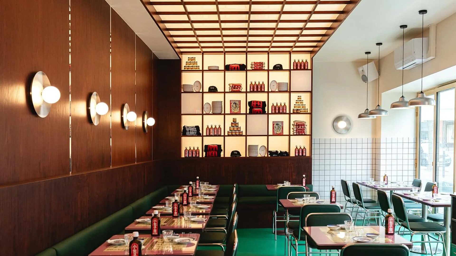 Restaurant aux banquettes vertes, appliques en laiton et étagères éclairées